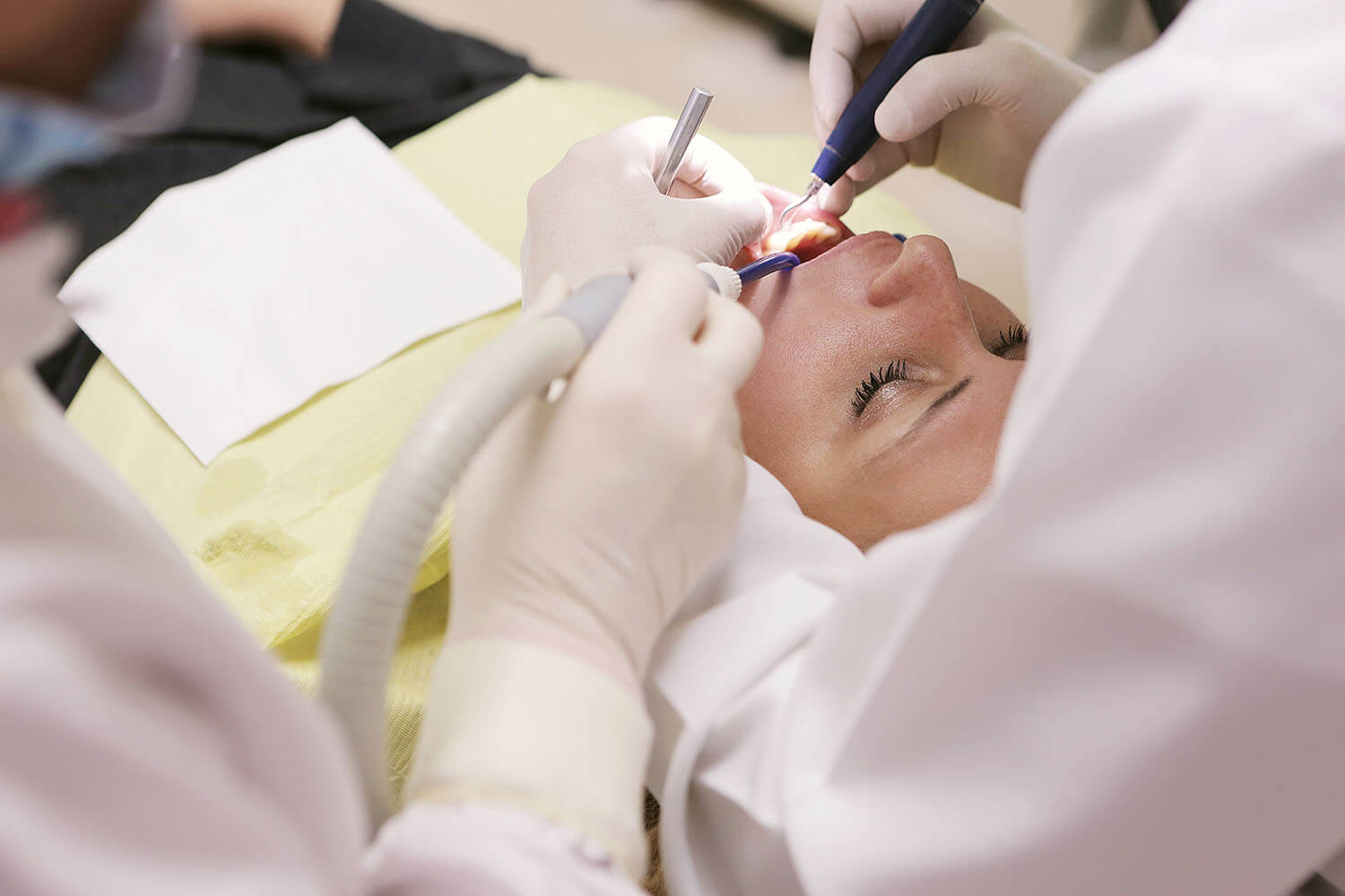 Two dentists attending to a patient
