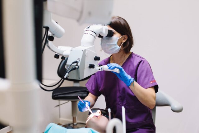 Dentist using a microscope to check a patient