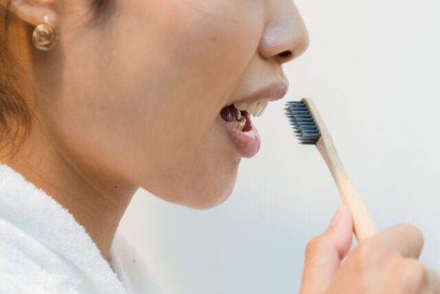 Woman going to brush her teeth with a toothbrush